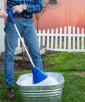 Person using a Portable Manual Clothes Washer Plunger with blue head in a bucket for laundry in outdoor setting.