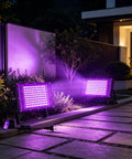 2 Pack 100W Black Light Flood Light Blacklight for Glow Party illuminating outdoor garden with vibrant purple glow.