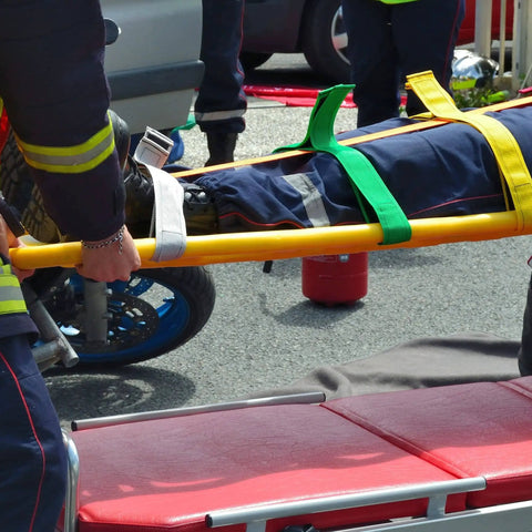 Color Coded Backboard Spine Board Straps For Quick Immobilization On Stretcher 10 Point System Industrial Grade Nylon Spider Straps For EMS Pros And Medical Teams in use by emergency responders on a stretcher.