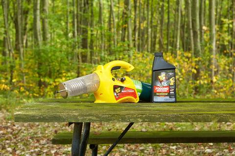 32 Oz Ready To Use Fogging Insecticide For Mosquitoes, Biting Flies, And Flying Insects In Lawns, Patios, And Gardens Compatible With Thermal Foggers Today shown on a picnic table with a fogger in a forest setting
