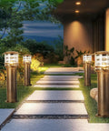 Weatherproof Aluminum Post Cap Lights For Deck And Yard With Bright Acrylic Diffuser illuminating a stone pathway in a garden.