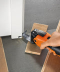 Fein Starlock Plus oscillating multi-tool (orange) cutting wood with attached metal saw blade