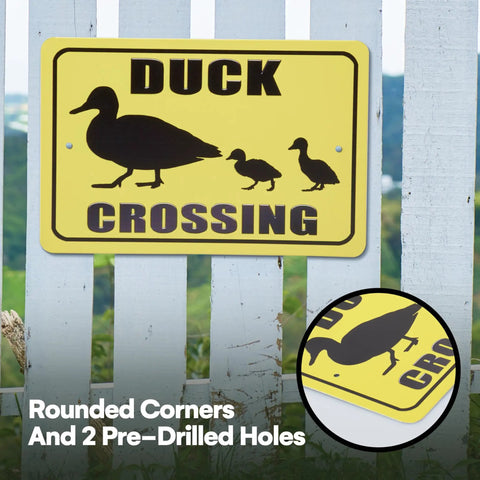 Reflective Duck Crossing sign on fence with black silhouette of ducks, yellow background, and rounded corners for outdoor safety.