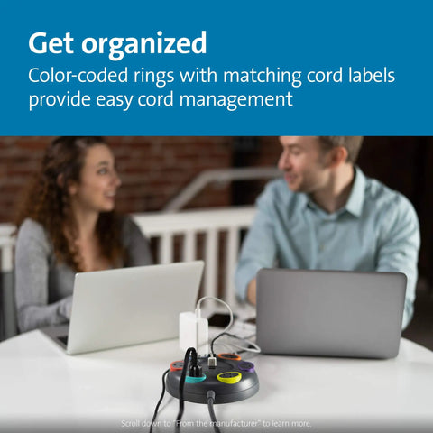 Six Outlet Surge Protector With A 16 Foot Cord And 1500 Joules Of Tabletop Surge Protection, Color Coded Rings For Easy Cord Management, A No-Brainer Way To Outfit Desks, PCs, Monitors, And Home Setups in use at an office desk with two people working on laptops.
