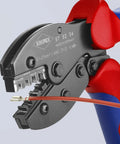 4-Position Contact Crimping Pliers with precise dies in use on wire, red and blue handle, AWG 27-13, 0.1-2.5 sq mm capacity