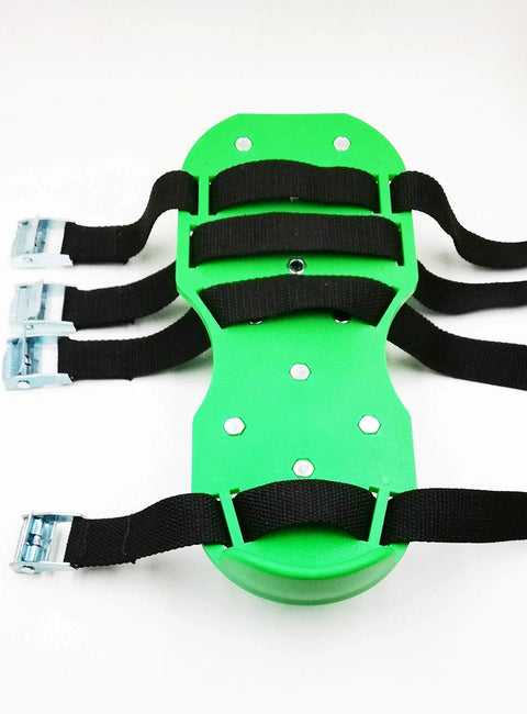 Close-up of green 6.8 cm lawn aerator spike shoes with heavy duty buckles and four adjustable straps.