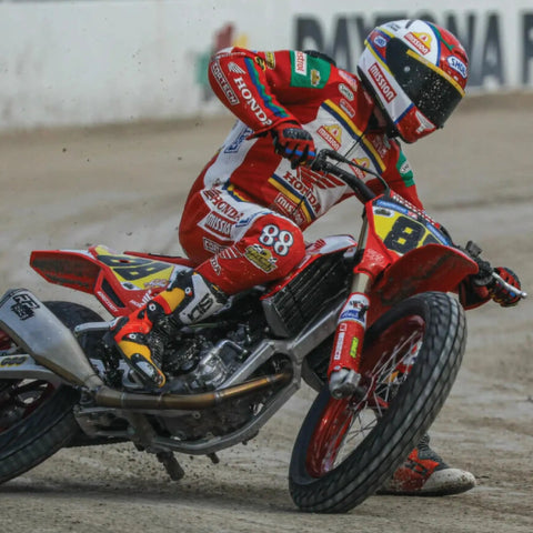 Dirt bike with 130/80-19 FT30 tire racing on flat track, showcasing traction on hard pack and loose surfaces, front wheel use.