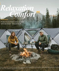 Two campers sitting by a fire with Oversized Camping Wind Block Screen Four Panels Campout Ready For Beach And Backyard Privacy Fence Sun Shield With Mesh Window Poles Ground Nails Included Easy Setup Green in the background.