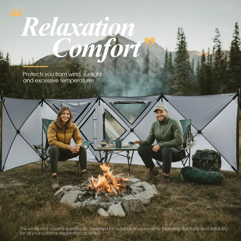 Two campers sitting by a fire with Oversized Camping Wind Block Screen Four Panels Campout Ready For Beach And Backyard Privacy Fence Sun Shield With Mesh Window Poles Ground Nails Included Easy Setup Green in the background.