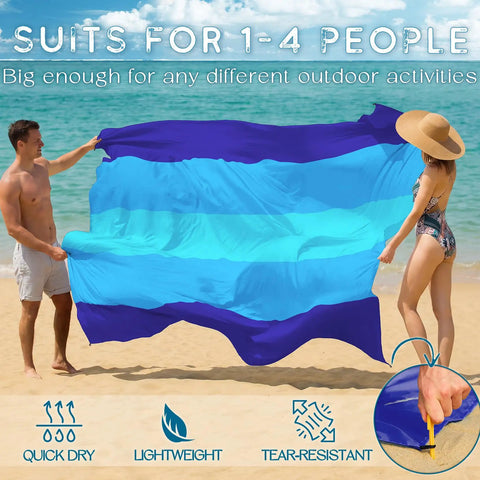 Oversized Beach Blanket 78 By 81 Inches Go-To Picnic Mat for 4 to 7 Adults waterproof and sandproof in blue, held on a beach.