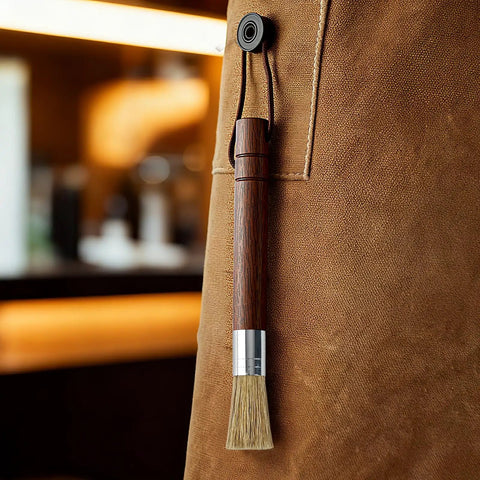 Grinder Cleaning Brush Set With Walnut Wood Handle And Natural Bristles For Espresso Machines And Home Baristas hanging on apron