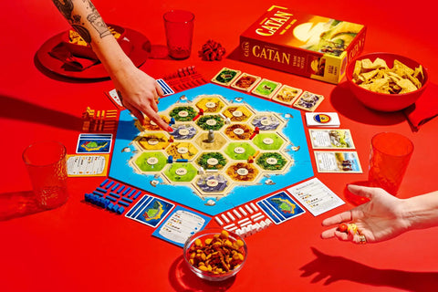 Premium Island Settlement Building Strategy Board Game For Families And Crew Ages 10 Plus Master Resource Trading Expand Territories For An Epic Hella Fun Tabletop Adventure with game board and snacks.