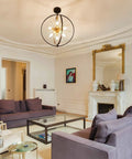 Living room with Modern Sputnik Style 6 Light Starburst Chandelier, 18-Inch Globe Fixture In Black And Gold hanging from ceiling.