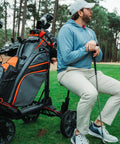 Electric Golf Push Cart With Roomy Seat Featuring Full Directional Remote Nine Speed Levels Mileage Counter Screen And Trueline Tracking for lounging golfer.