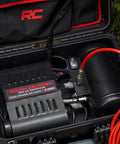 Tough As Nails Portable 12V Dual Cylinder Air Compressor Pump 150 Psi And 6 16 Cfm in sturdy case with red hose.