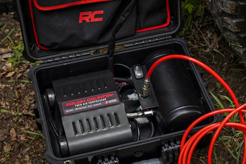 Tough As Nails Portable 12V Dual Cylinder Air Compressor Pump 150 Psi And 6 16 Cfm in sturdy case with red hose.