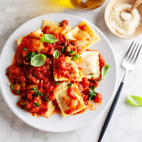Plate of homemade ravioli with tomato sauce made using Ravioli Cutter and Pastry Wheel for Fresh Pasta and Dough That Seals Crimps and Cuts Perfectly With 18 10 Stainless Steel Build Awesome for Homemade Ravioli Pastry Crusts and Dough
