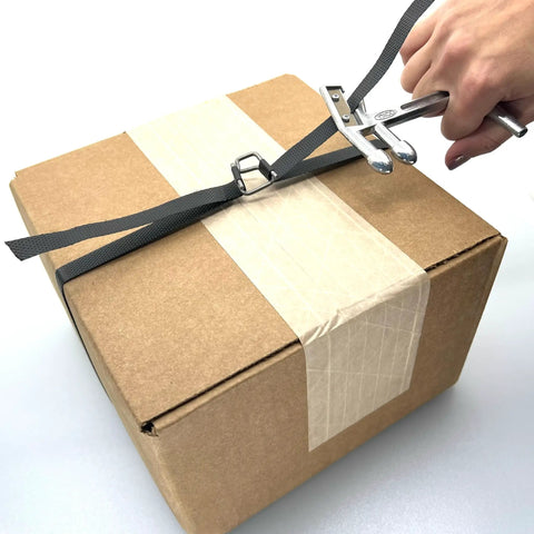 Portable One Half Inch Polypropylene Strapping Kit With Mini Coil Tool And Buckles in use on a cardboard box