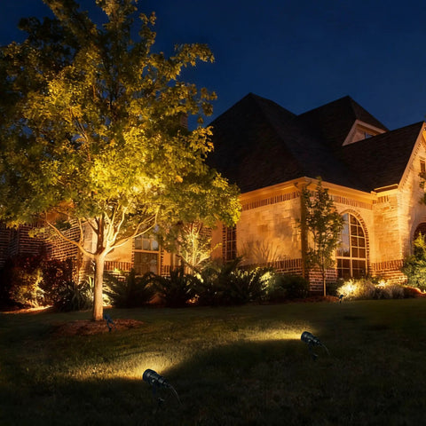 All-In-One Low Voltage Landscape Lighting Kit 8 Pack 5W Die-Cast Aluminum Outdoor Spotlights illuminating house and tree at night
