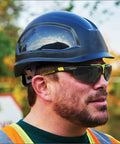 Sick Clear Vision Transition Safety Glasses With Anti Fog Coating And Scratch Resistant Lenses Featuring Adjustable Non Slip Fit For Legit All Day Comfy ANSI Certified Protection on a worker wearing a hard hat outdoors.