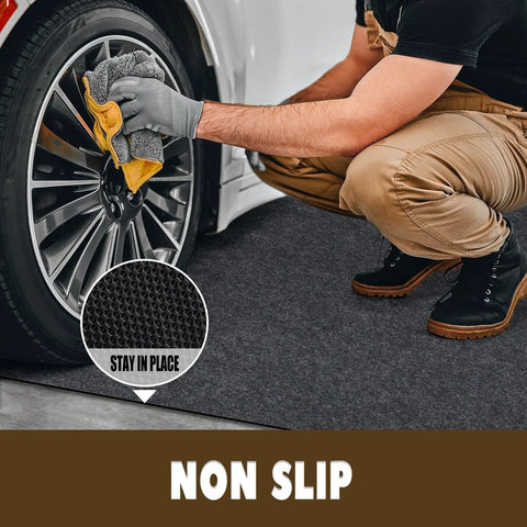 Oil Spill Mat For Garage Floor 3 By 7 Feet Under Motorcycle Waterproof Durable Non Slip TPR Backing Reusable Absorbent Pad Charcoal Heavy Duty Oil And Water Drip Catcher For Workshop And Garage, shown placed under a wheel with a man cleaning.