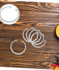 5 Piece Stainless Steel C Clip Retaining Ring Set for Pins Shafts and Studs on a wooden surface