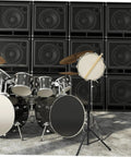 Heavy Duty Adjustable Height Tripod Snare Drum Rack Stand With Slick Black Alloy Finish For Rock Solid Practice And Tour Ready Drummer Gear Organization next to a black drum set.