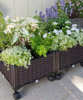 Two Piece Rolling Garden Bed Kit With Self Watering Design In Brown Plastic Outdoor Elevated Planter Boxes On Wheels For Easy Mobility And Space Saving Balcony Garden with green plants and flowers.