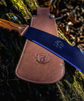 All In One Survival Machete And Brush Axe With Sheath For Camping Fishing Hunting And Bushcraft A Heavy Duty Outdoor Tool on forest floor.