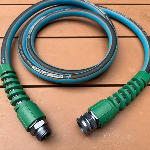 Heavy Duty Five Eighth Inch Garden Hose Fittings Kit Two Pack Metal Male Connectors With Bend Restrictor on wooden surface.