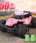 Remote Control Monster Truck For Kids With Crazy Long Battery Life 50 Minute Playtime 1 12 Scale 13 Inch All Terrain RC Truck With Flashing Chassis Lights 20 Kmh Speed Great Gift For Girls And Boys, pink monster truck with extra batteries on a road