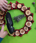 Person using 100 Watt High Temperature Heavy Duty Hot Glue Gun For Packaging Woodworking DIY Repairs And Crafts Beast Pro Grade Power Melt Fast And Consistent Bonds For Demanding Projects to glue a wreath