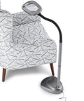 MultiFlex LED Floor Magnifier Lamp With Ultra Wide 6 Inch Viewing Area next to chair, silver finish, adjustable neck