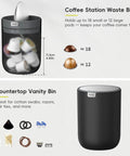 Compact Swing Top Mini Trash Can With Lid For Bathroom Vanity Countertop Desk Or Office 2.2L 7.3In Tall 5.3In Diameter Black Space Saver Tiny Trash Bin For Small Spaces shown as a vanity bin with various small items.