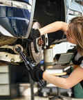 Mechanic using 12V Li-Ion Cordless 3/8 Inch Extended Drive Ratchet Wrench Kit With Built-In LED Light on car wheel