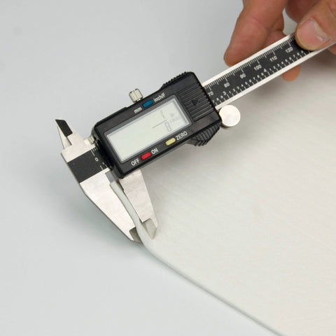 High-temperature gasket paper sheet in light gray, 1/8 in thick x 7×10 in, close-up with caliper.