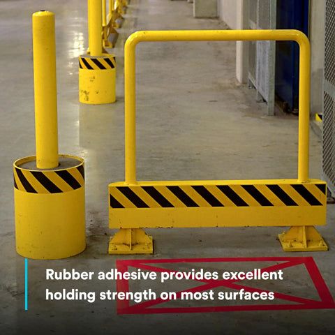 Yellow barrier and pole marked with High Visibility Striped Vinyl Safety Tape for Lane and Floor Marking, Rubber Adhesive, 2 Inch By 36 Yard, 5.4 Mil, Easy Clean Removal, Durable Workhorse Caution Tape, Abrasion-Resistant Black Yellow in an industrial setting.