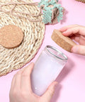 Person placing Two Pack Cork Bottle Stoppers Set For Jars And Glass Bottles, Tapered Natural Wood Lids on a jar next to straw mat.