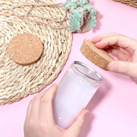 Person placing Two Pack Cork Bottle Stoppers Set For Jars And Glass Bottles, Tapered Natural Wood Lids on a jar next to straw mat.