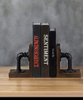 Legit Industrial Bookends Featuring Charred Pine And Genuine Metal Pipe Fittings And Badass 2 Piece Set For Modern Farmhouse Desks and Rustic Steampunk Home Decor, holding three books on a wooden table.