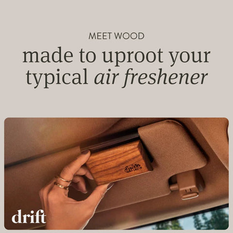 Front view: Drift teak wood car air freshener block held in hand inside a car, with drift logo.