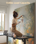 Boss Level Electric L Shaped Standing Desk Adjustable Height 63 X 55 Inches with artist painting, 154lbs capacity in home office.