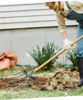 Person using a heavy duty steel farm fork with four prongs for soil loosening and turning in a garden