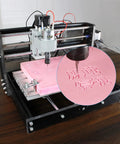 3 Axis DIY CNC Router Kit with GRBL Offline Controller engraving on pink material, aluminum frame, desktop size 18x10x4.5 cm
