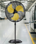 Beast Mode Heavy Duty Outdoor Pedestal Fan With 9600 CFM High Velocity Air, yellow blades, black stand, in a warehouse setting.