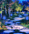 Blue Solar Torch Lights 8 Pack With Flickering Flame lighting a garden pathway at dusk