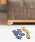 Heavy Duty Self Adhesive Furniture Sliders For Carpets 16 Pack 1.4 By 1 Inch Rectangle Glide Pads next to sofa leg on carpet