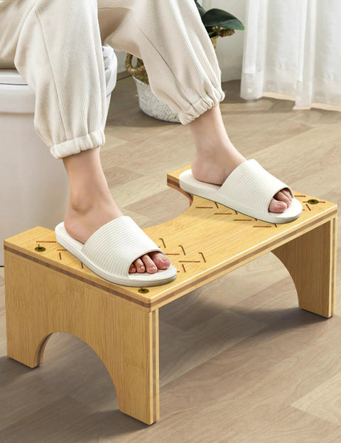 Person using Bamboo Poop Stool 7 Inch Toilet Step for Easy Pooping and Squatting, wood bathroom foot stool, anti slip layer visible