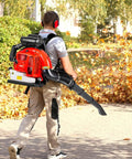Man using Professional Gas Powered Backpack Leaf Blower With 2 Stroke 63cc Engine Delivers 665 CFM Airflow in yard cleanup