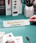 Person placing a card into a 24 Pack Acrylic Name Plates For Desk 2x8 Inches Clear Slant Back Sign Holders on a desk.